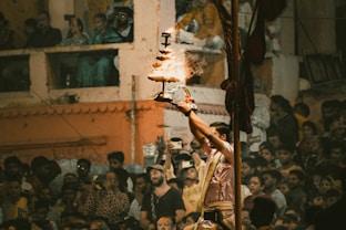 A crowd of people standing around a man holding a lit candle