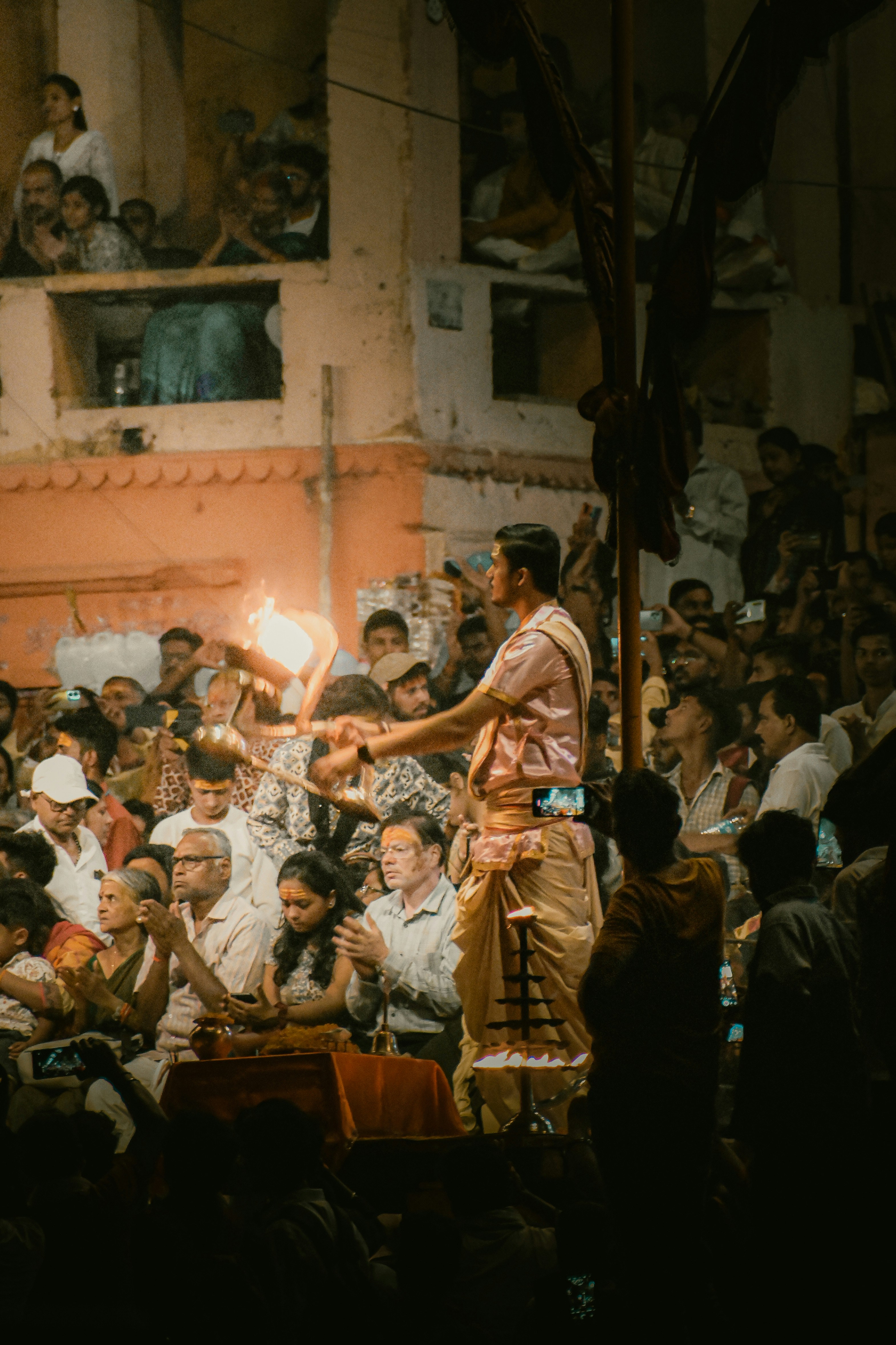 Un homme tenant une bougie allumée devant une foule
