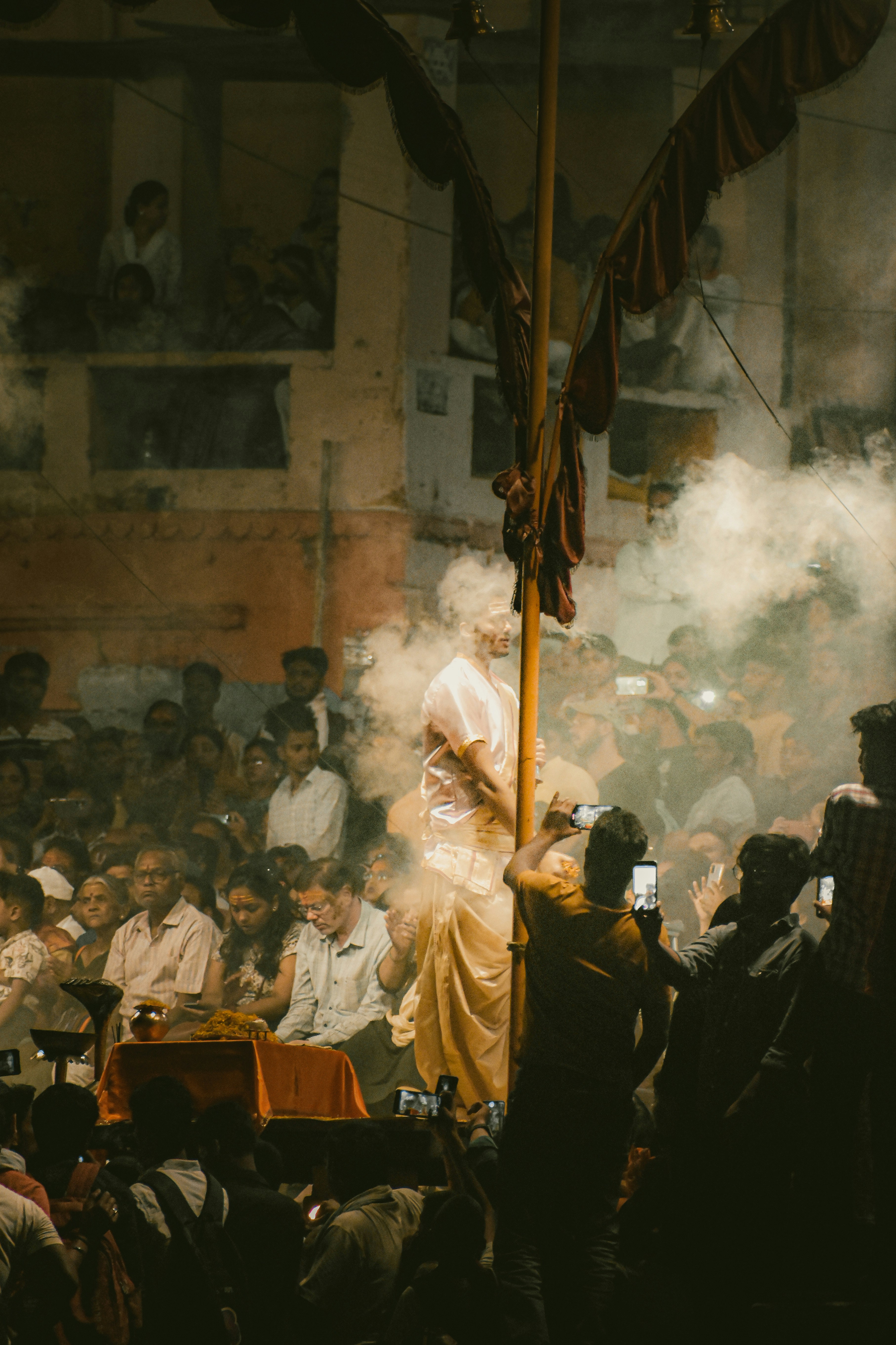 Une foule de personnes debout autour d’un mât de drapeau