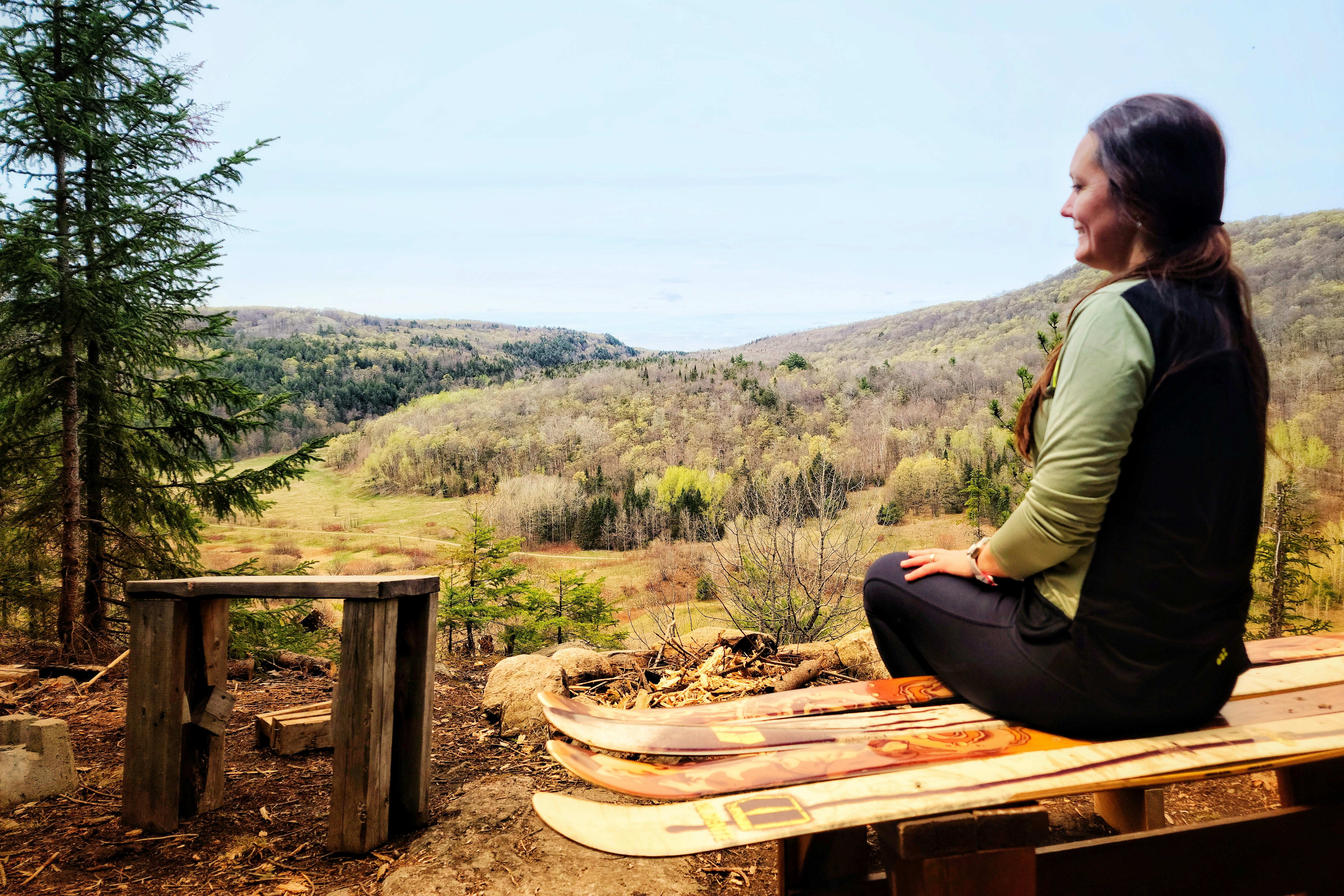 A woman sitting on a bench in the woods