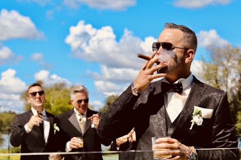 A man in a tuxedo smoking a cigarette