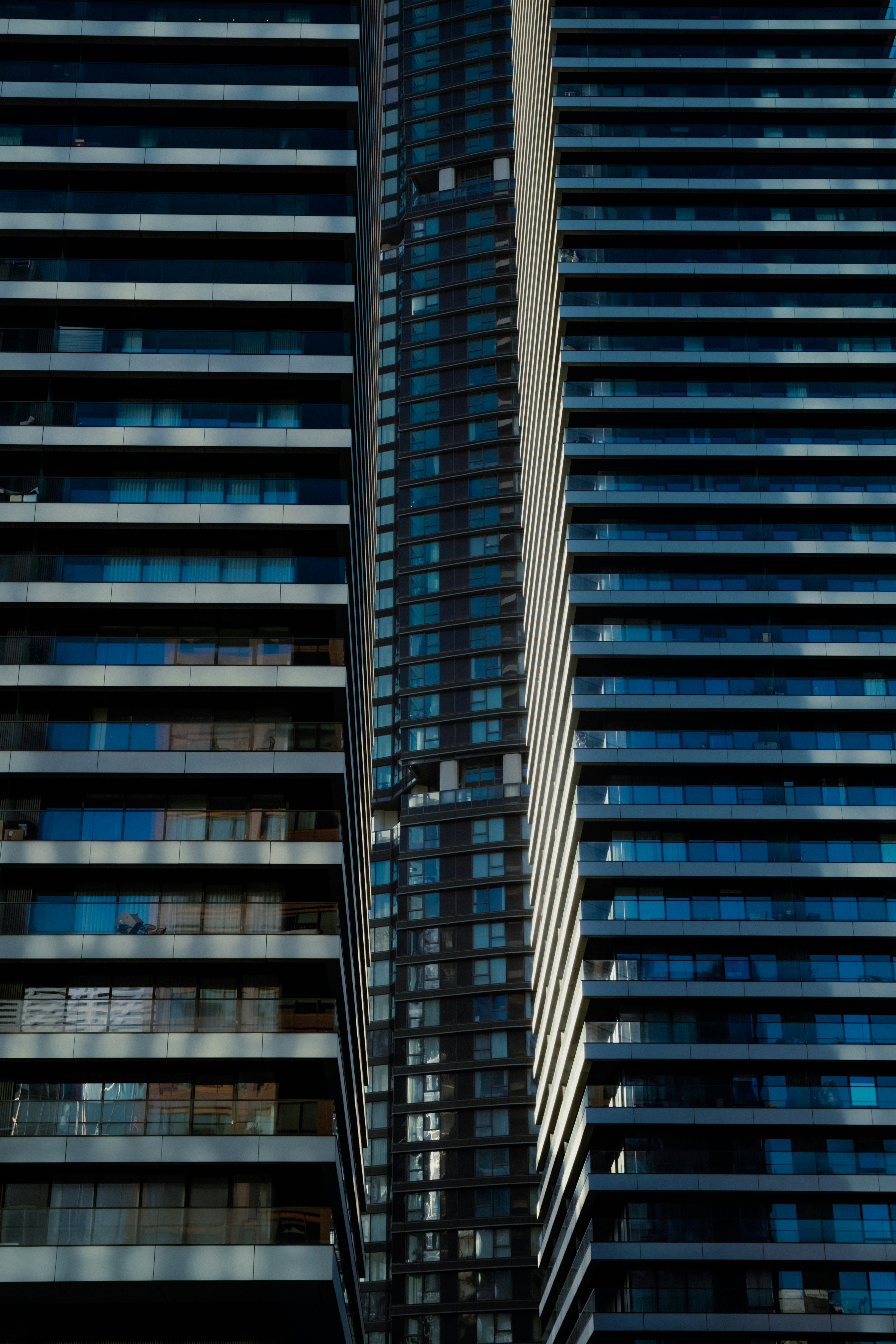 A tall building with lots of windows next to other buildings