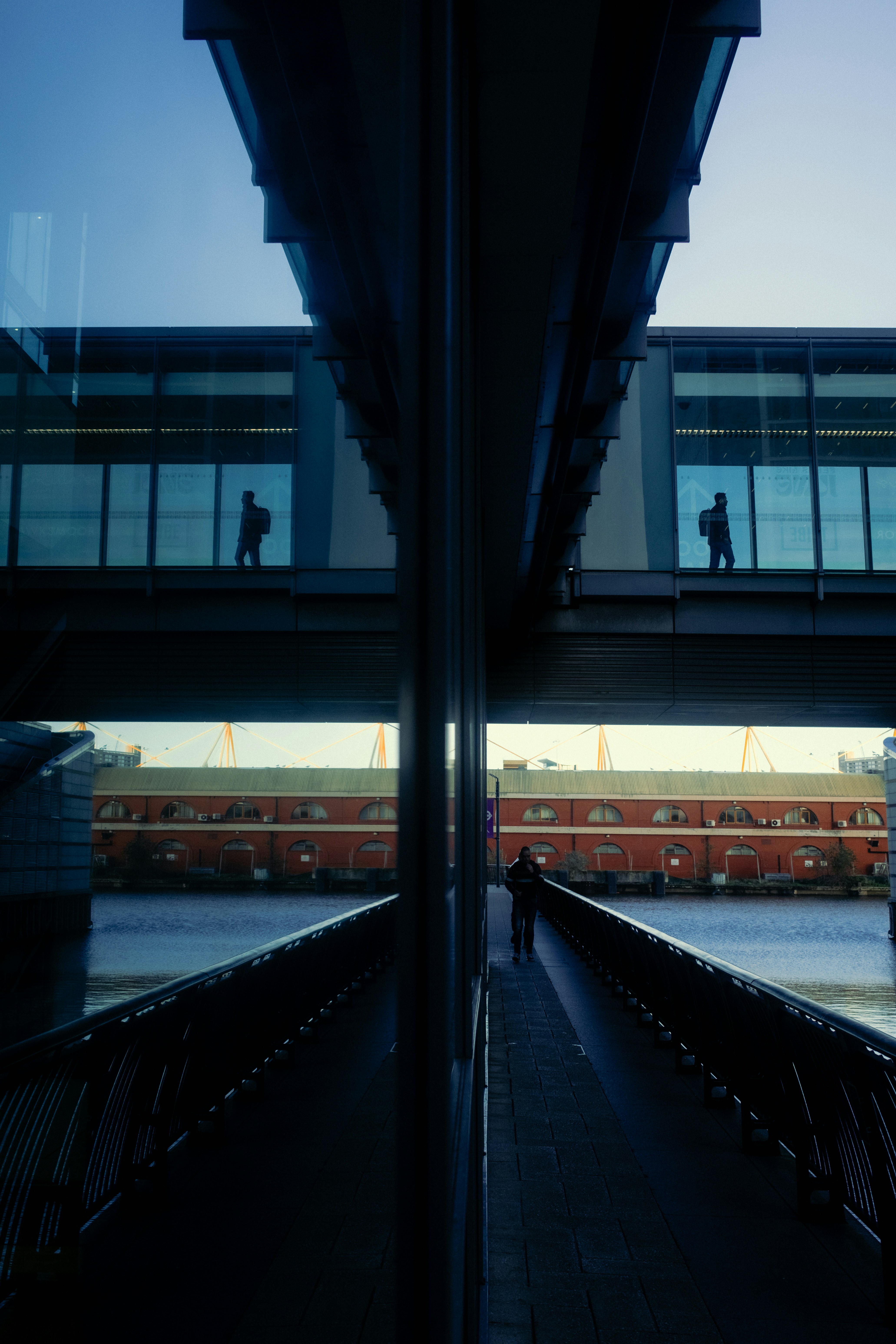 A reflection of a person walking across a bridge