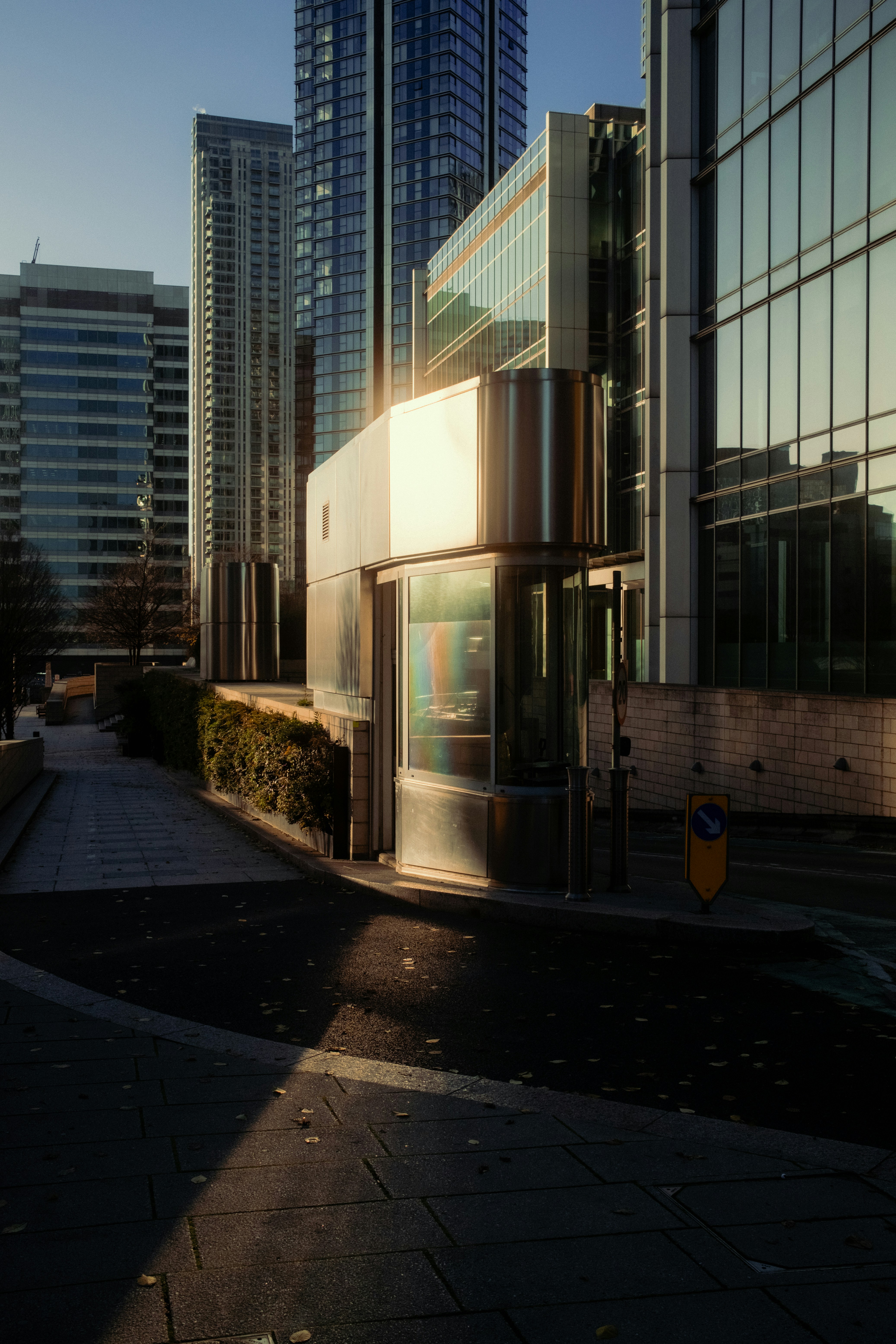 A city street lined with tall buildings next to a sidewalk