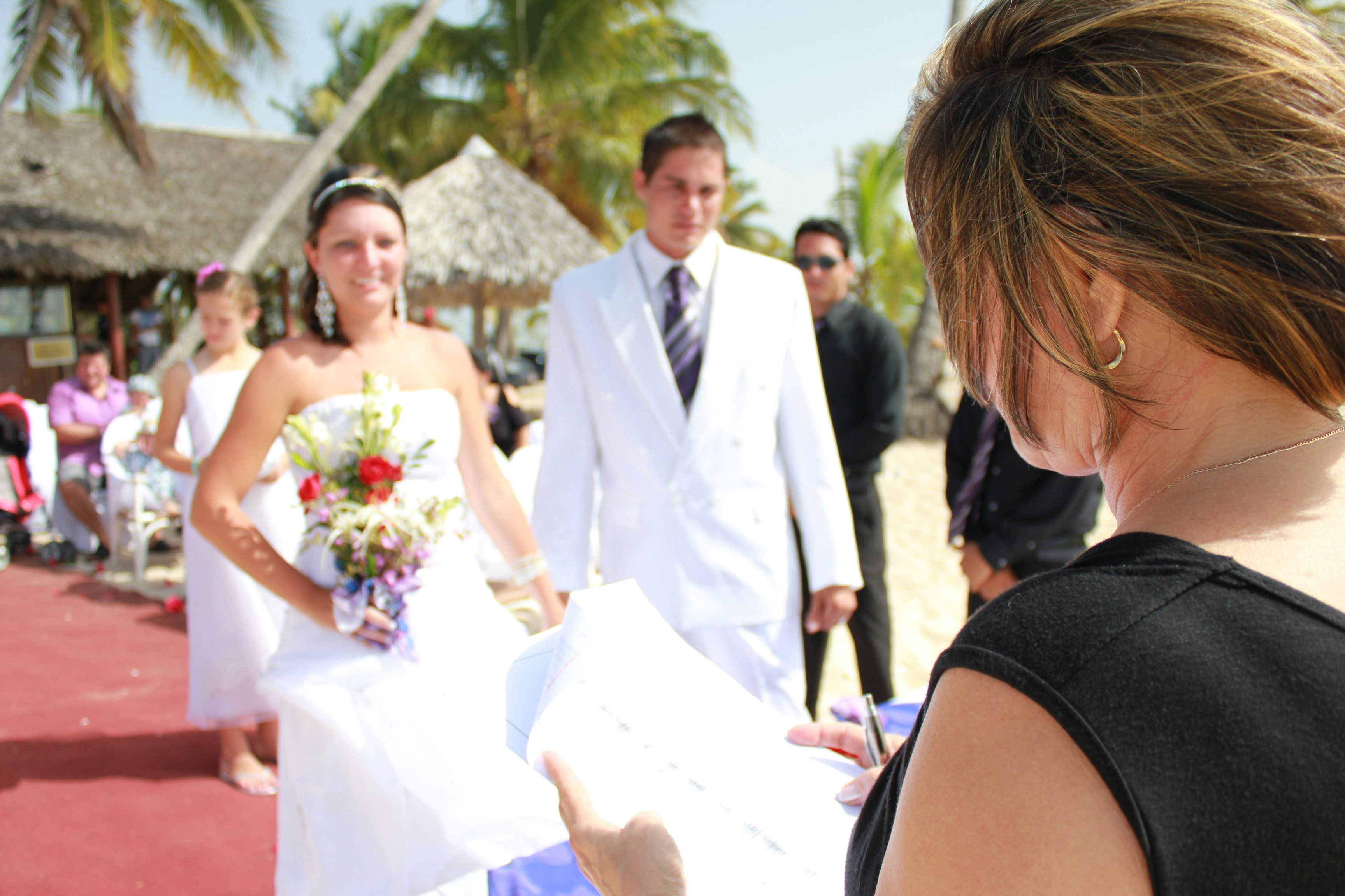 A woman in a white dress standing next to a man in a suit