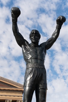 A statue of a man holding two boxing gloves