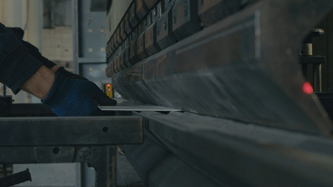 A worker operating a machine in a metal fabrication shop, the kind of business that prices jobs from an estimating workbook