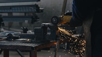 A person using a grinder on a piece of metal