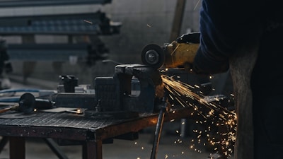 A person using a grinder on a piece of metal