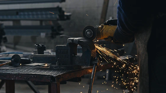 A person using a grinder on a piece of metal