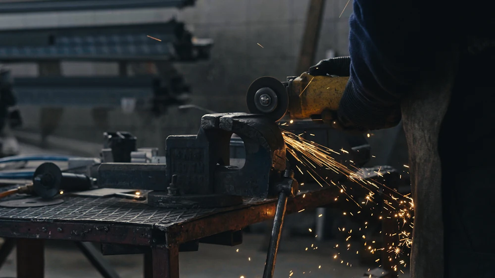 Technician grinding a metal section in the workshop
