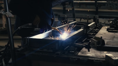 Welder working on a piece of metal in a factory