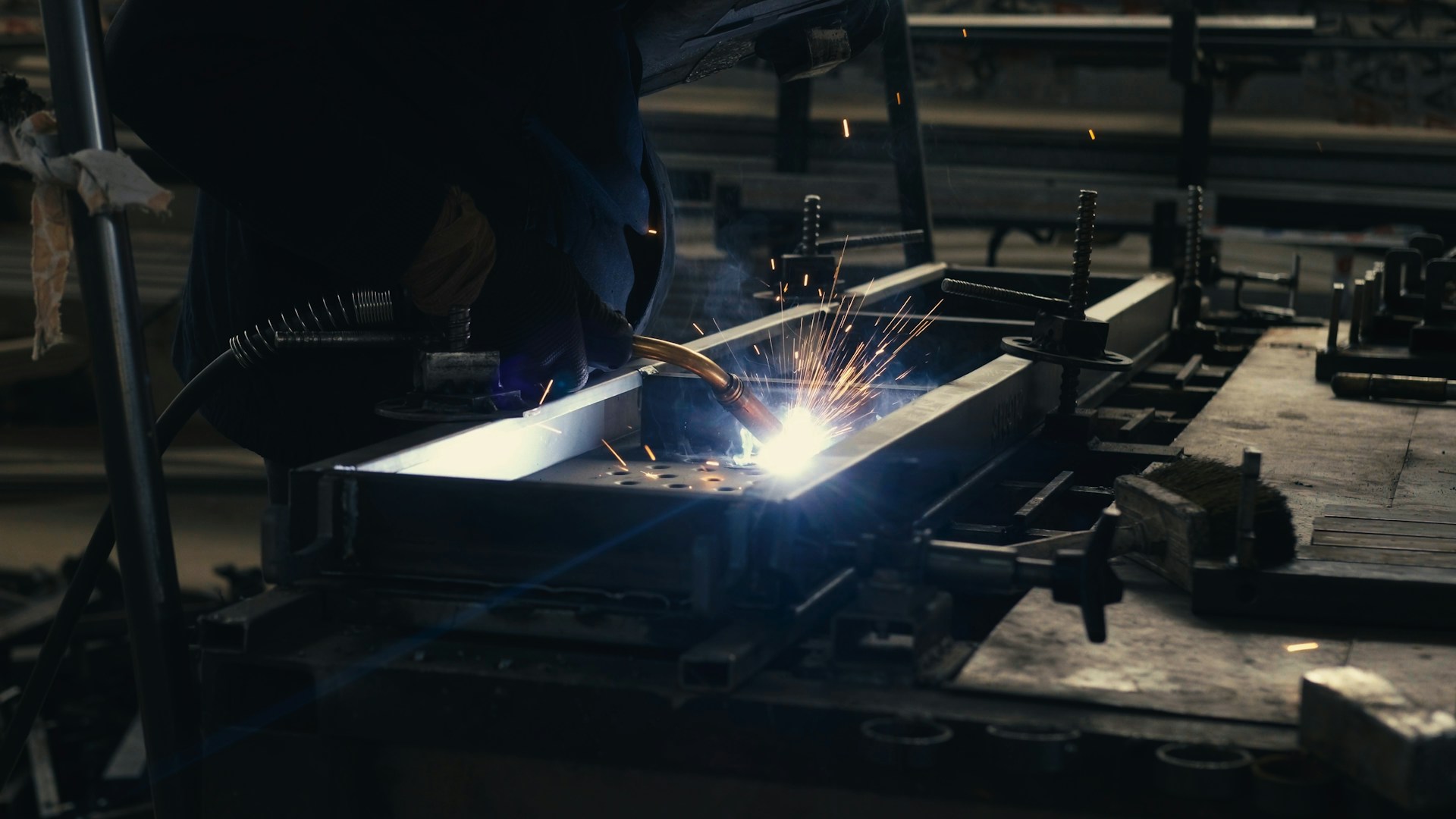 Welder working on a piece of metal in a factory