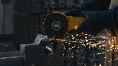 A person working with a grinder on a piece of metal
