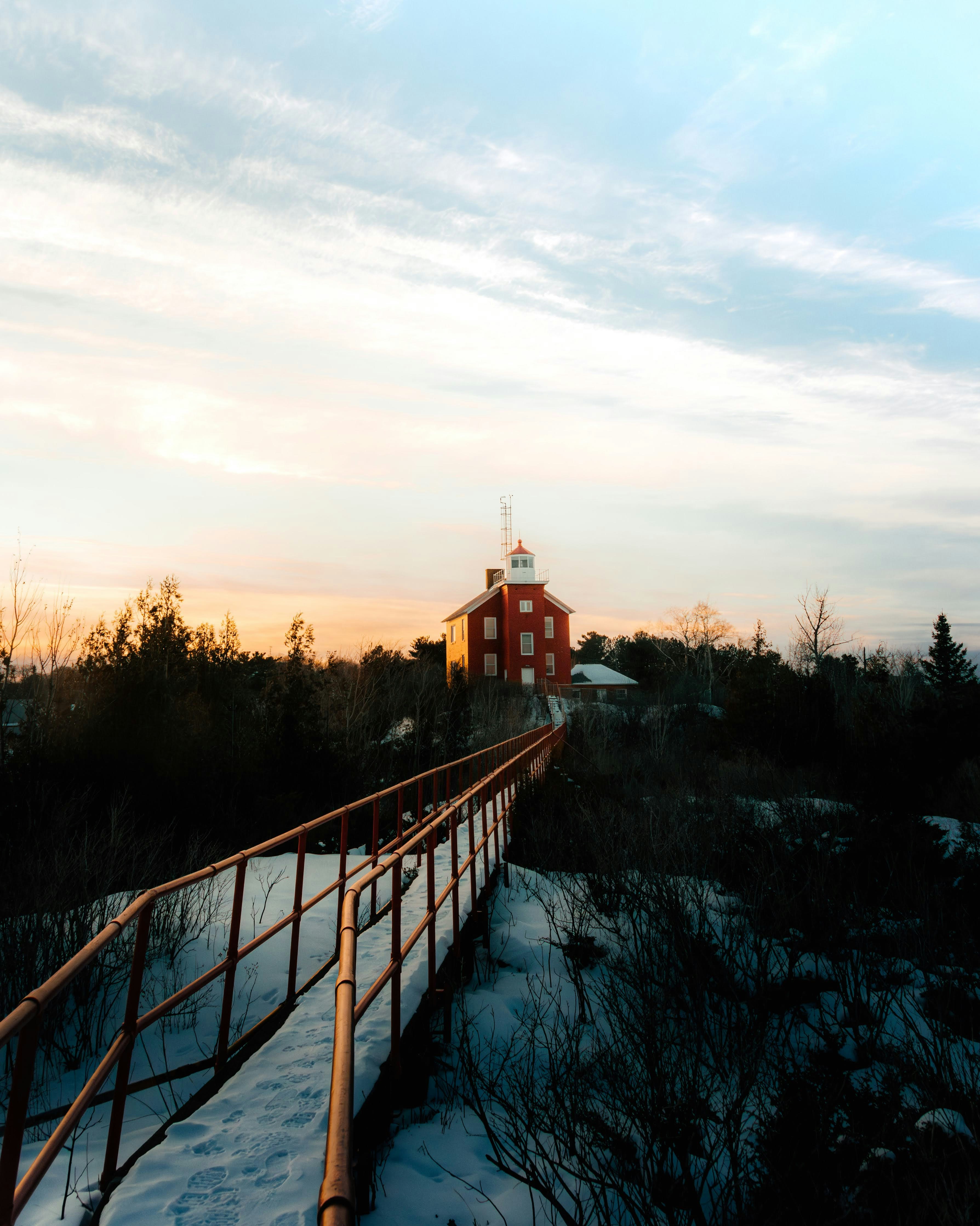 A wooden bridge with a red building in the background