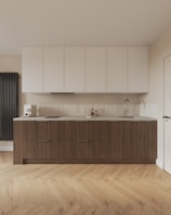 A large kitchen with a wooden floor and white cabinets