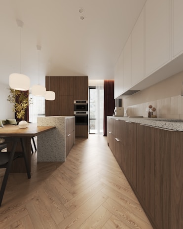 A large kitchen with a wooden floor and a dining table