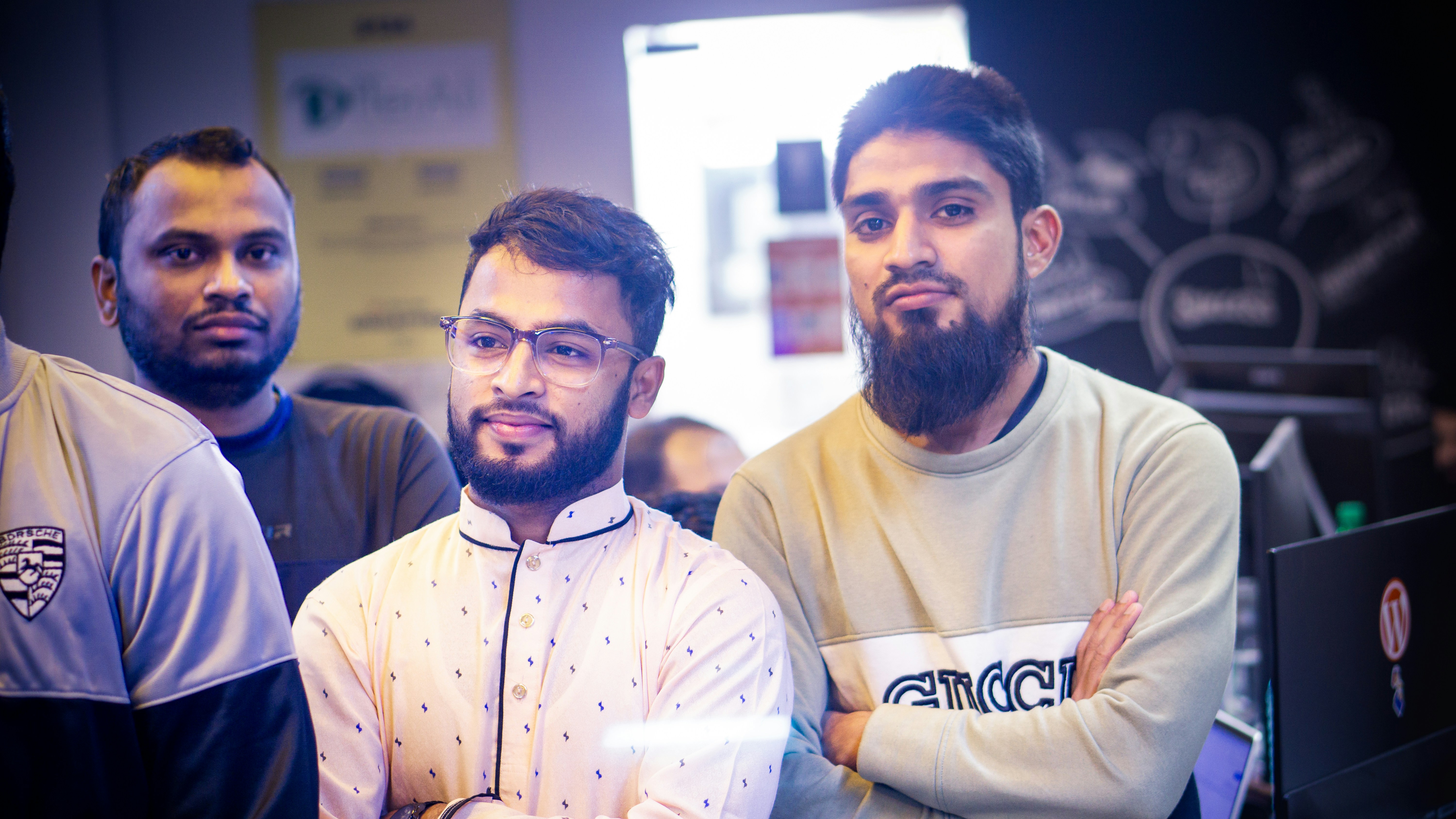 Zespół programistów analizuje kod na ekranach monitorów w nowoczesnym biurze