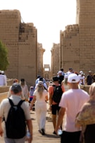A group of people walking down a street next to tall buildings