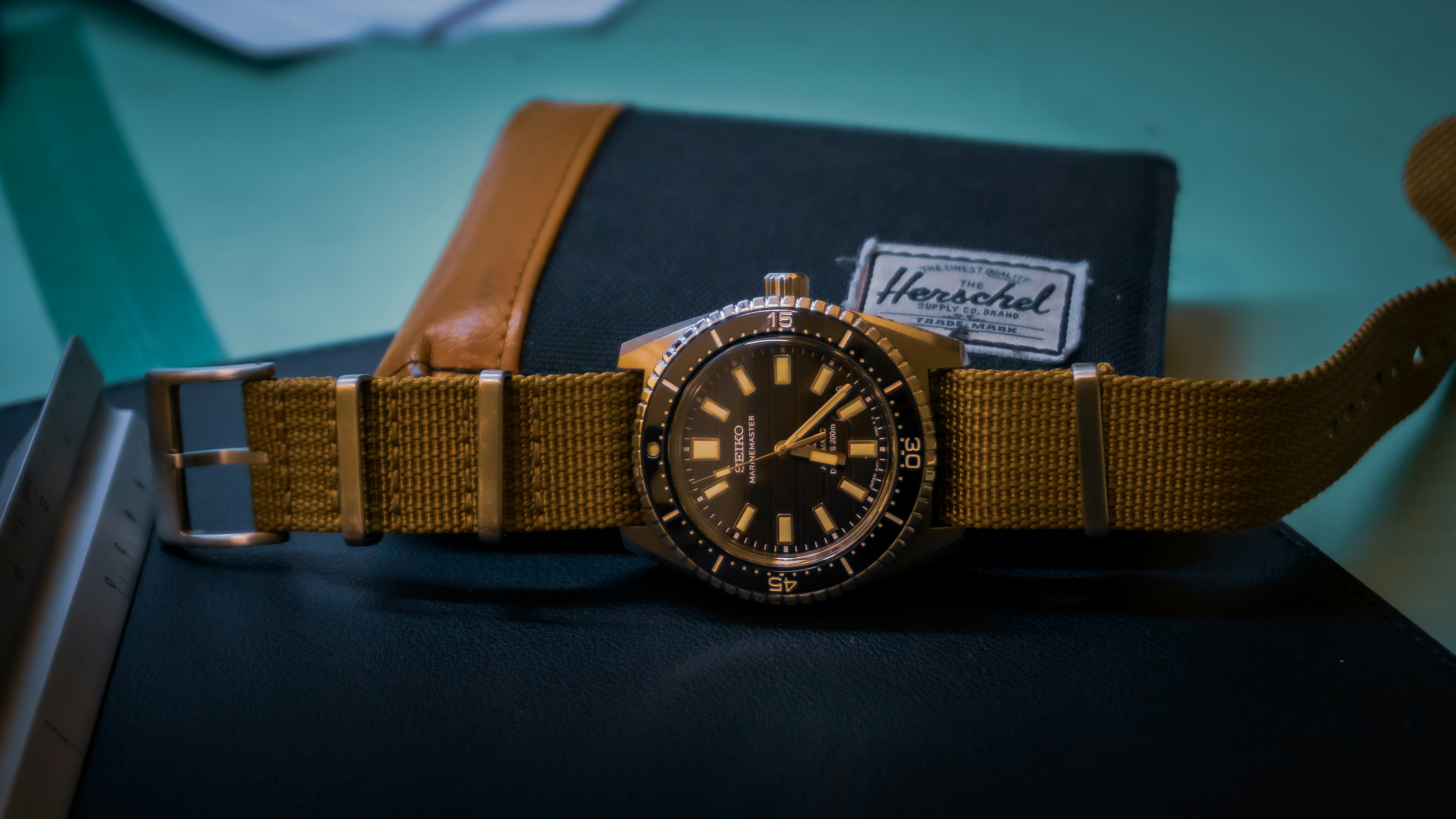 A watch sitting on top of a table next to a wallet