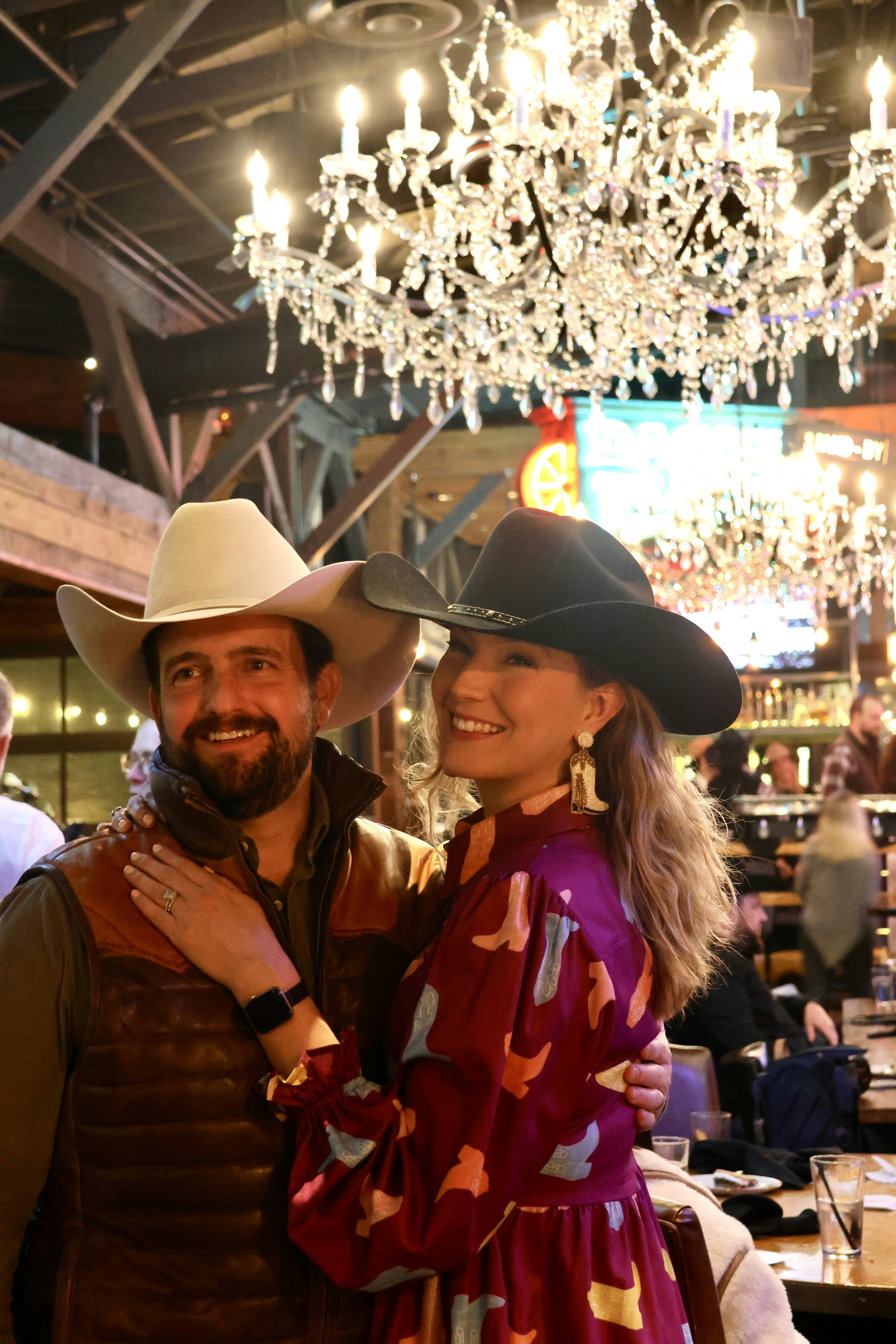 A man and a woman standing in front of a chandelier