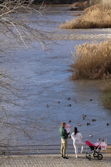 A group of people standing next to a body of water
