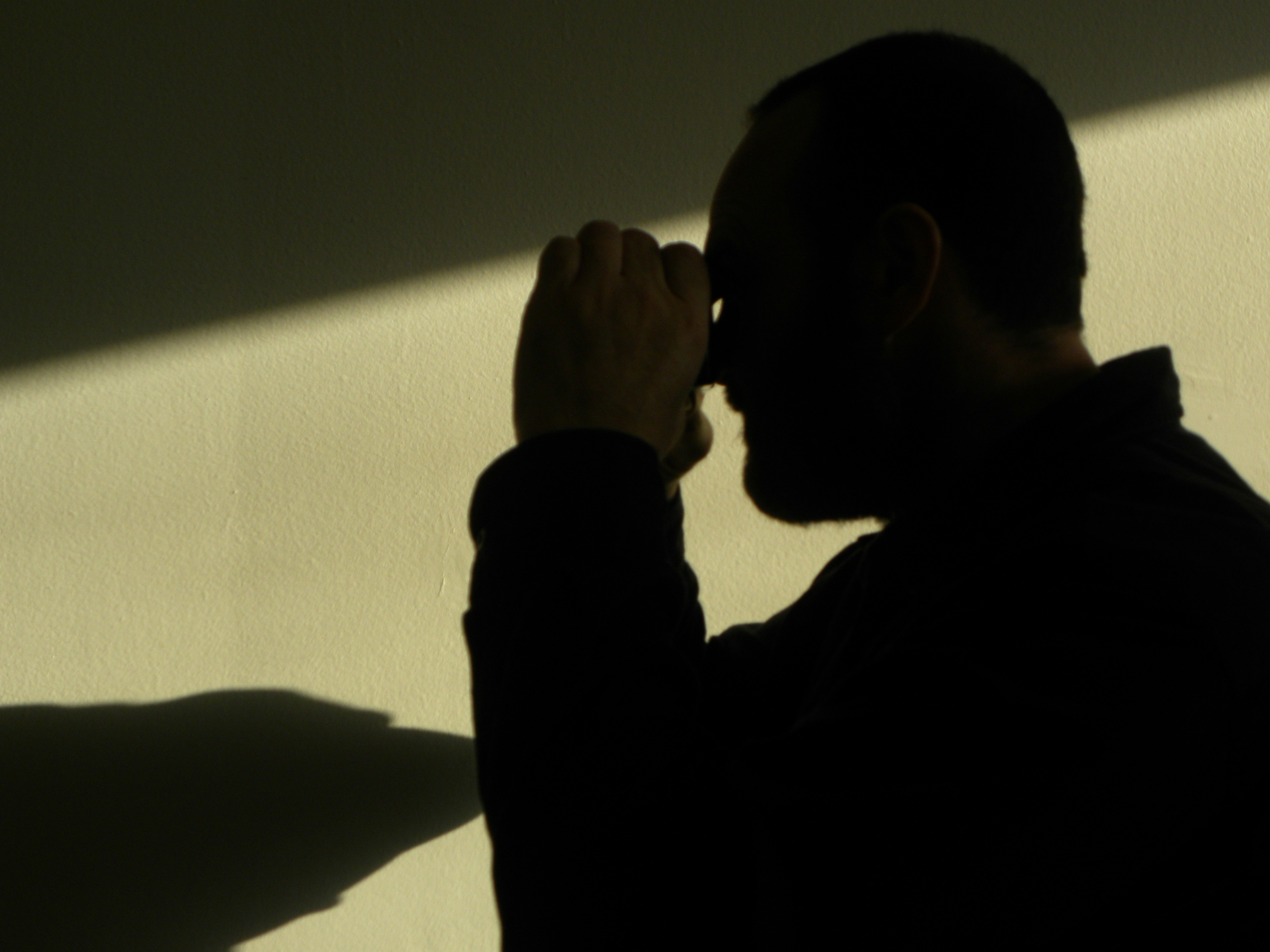 A man standing in the shadows of a wall