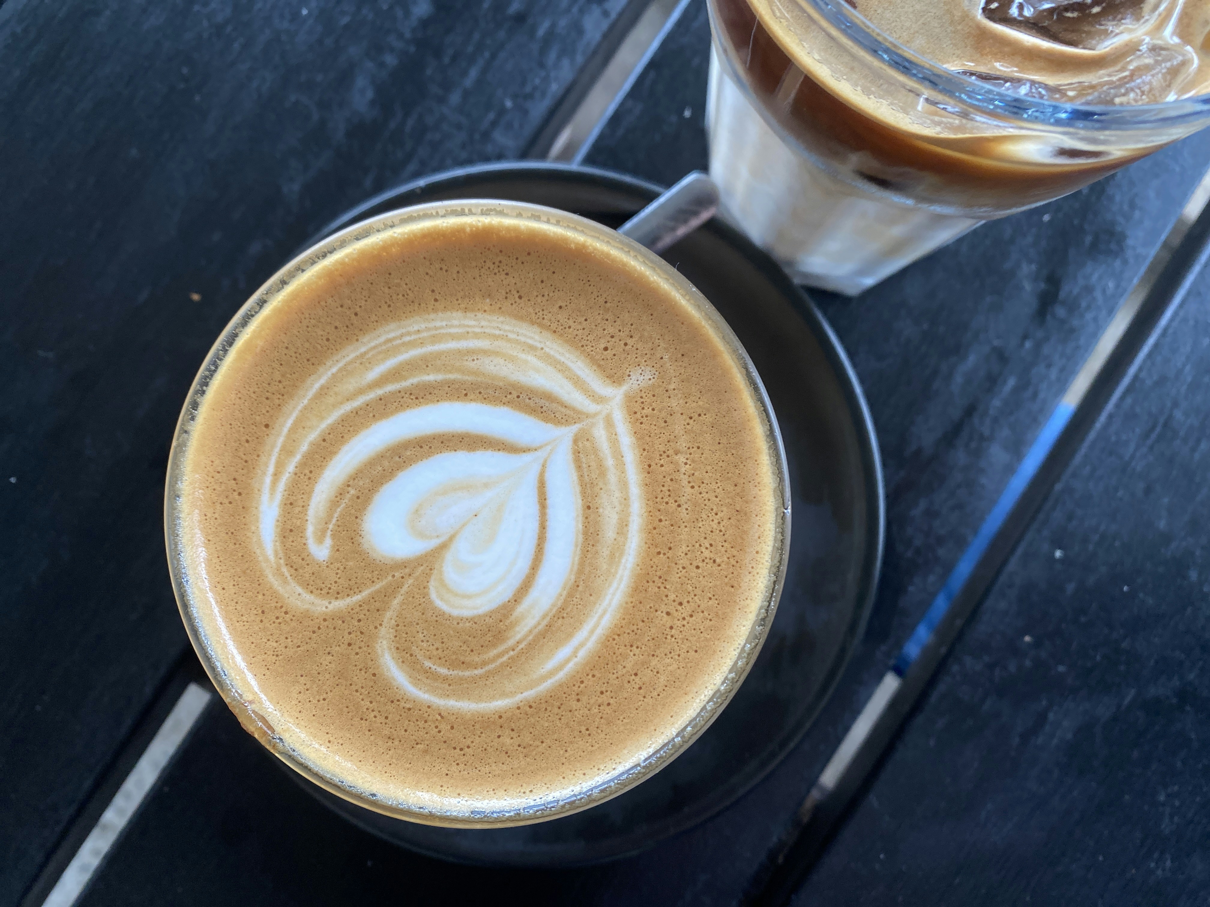 Two lattes with heart latte art on a dark table