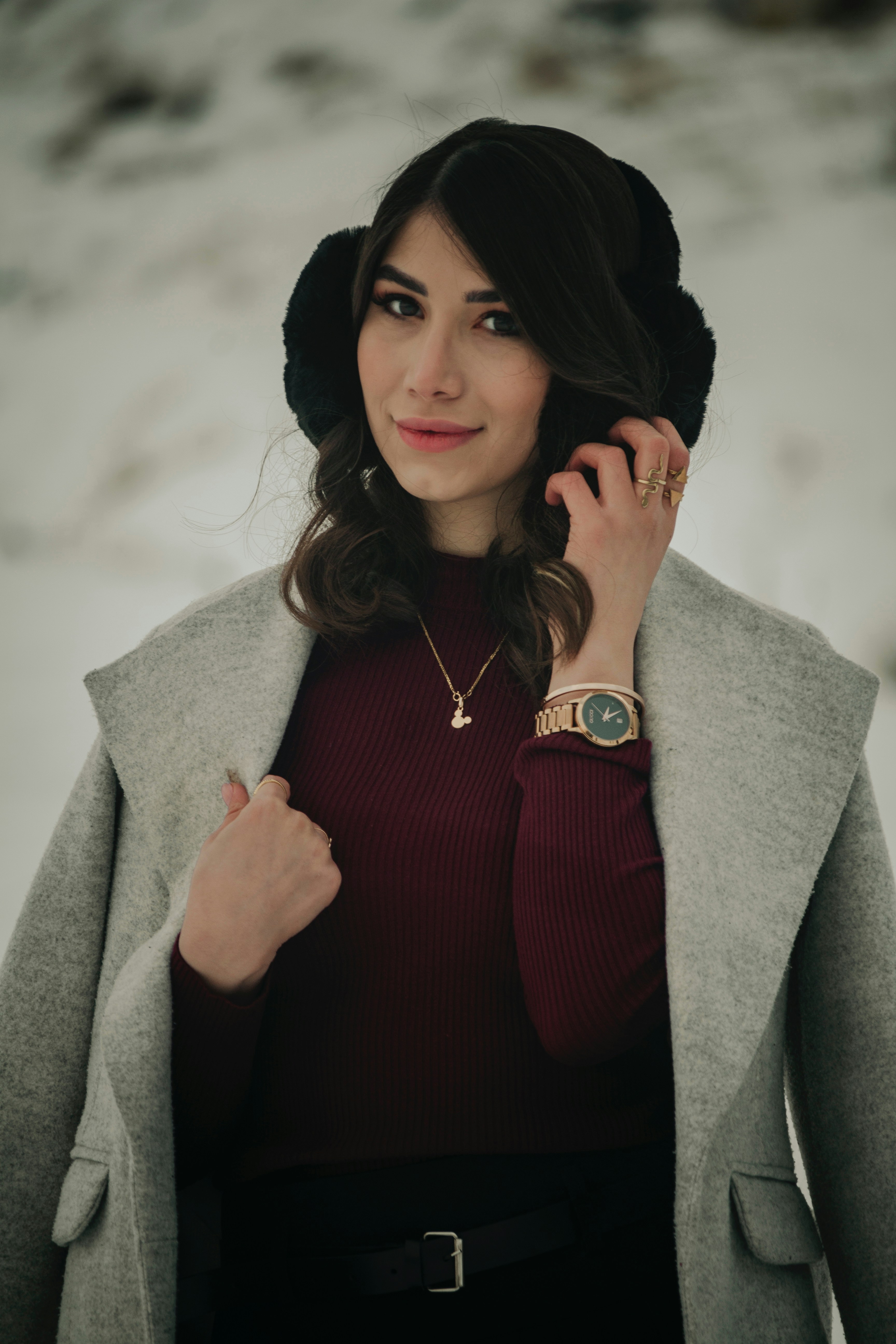 A woman in a red top and a gray coat