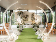 A wedding ceremony with a green carpet and white flowers