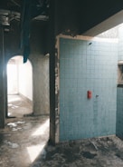 A bathroom with a blue tiled wall and floor