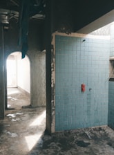 A bathroom with a blue tiled wall and floor