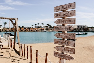 A wooden sign sitting on top of a sandy beach