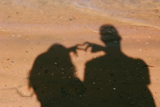 A shadow of a man and a woman on the beach
