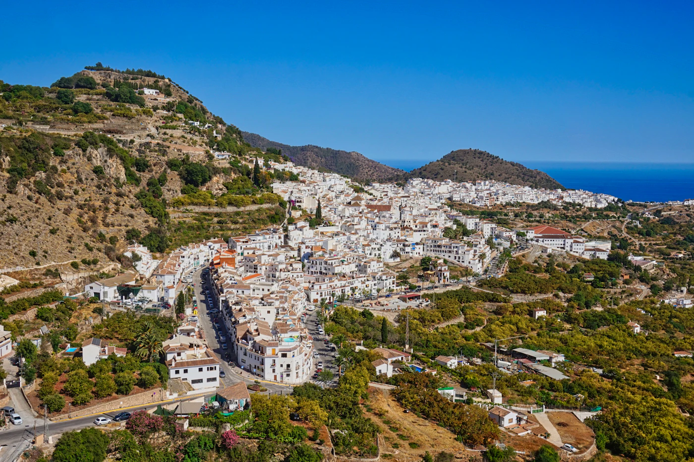 The white village of Frigiliana in Andalucía, surrounded by mountains, with the Mediterranean beyond