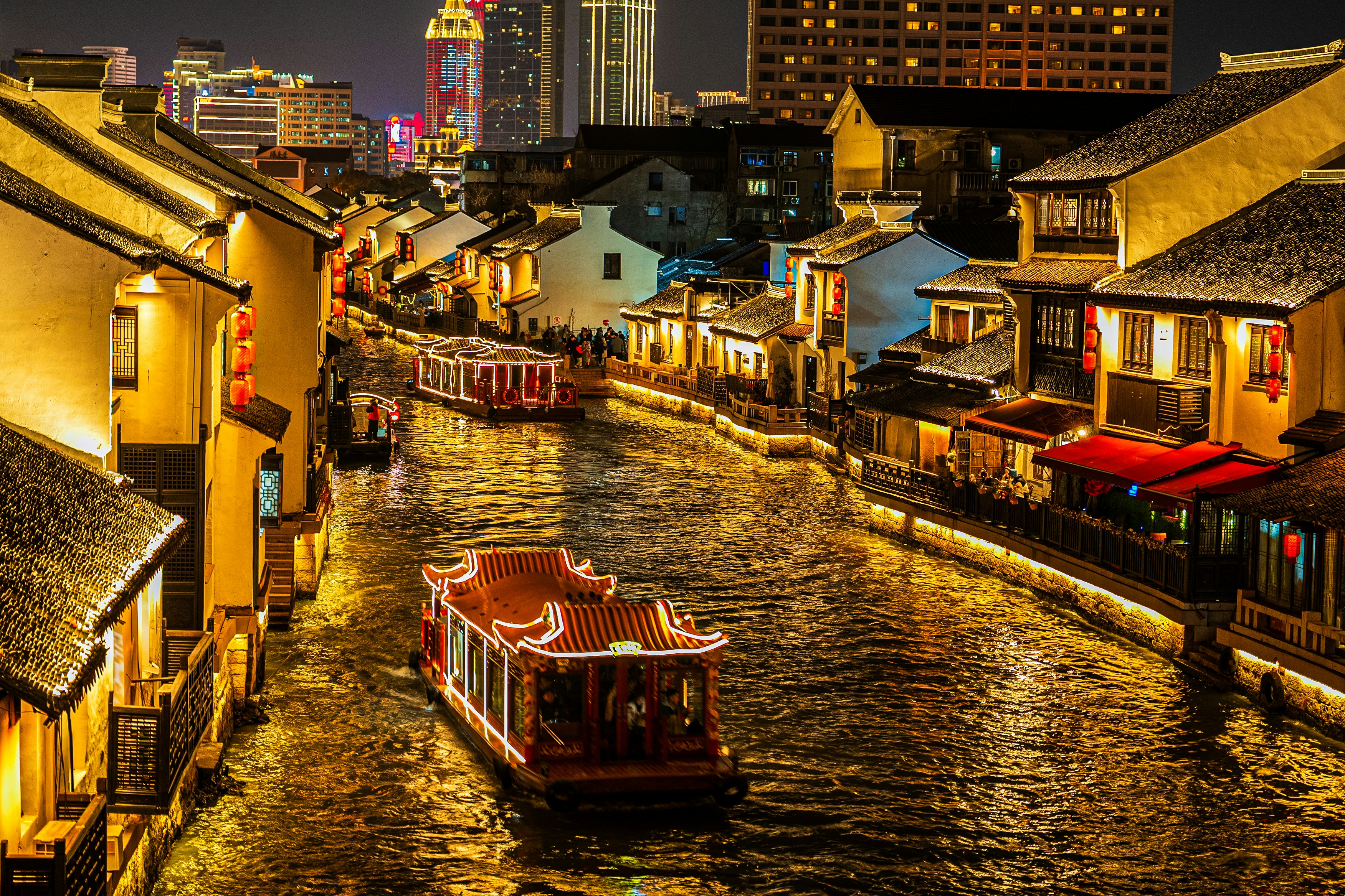 高層ビルの隣を川を下るボート