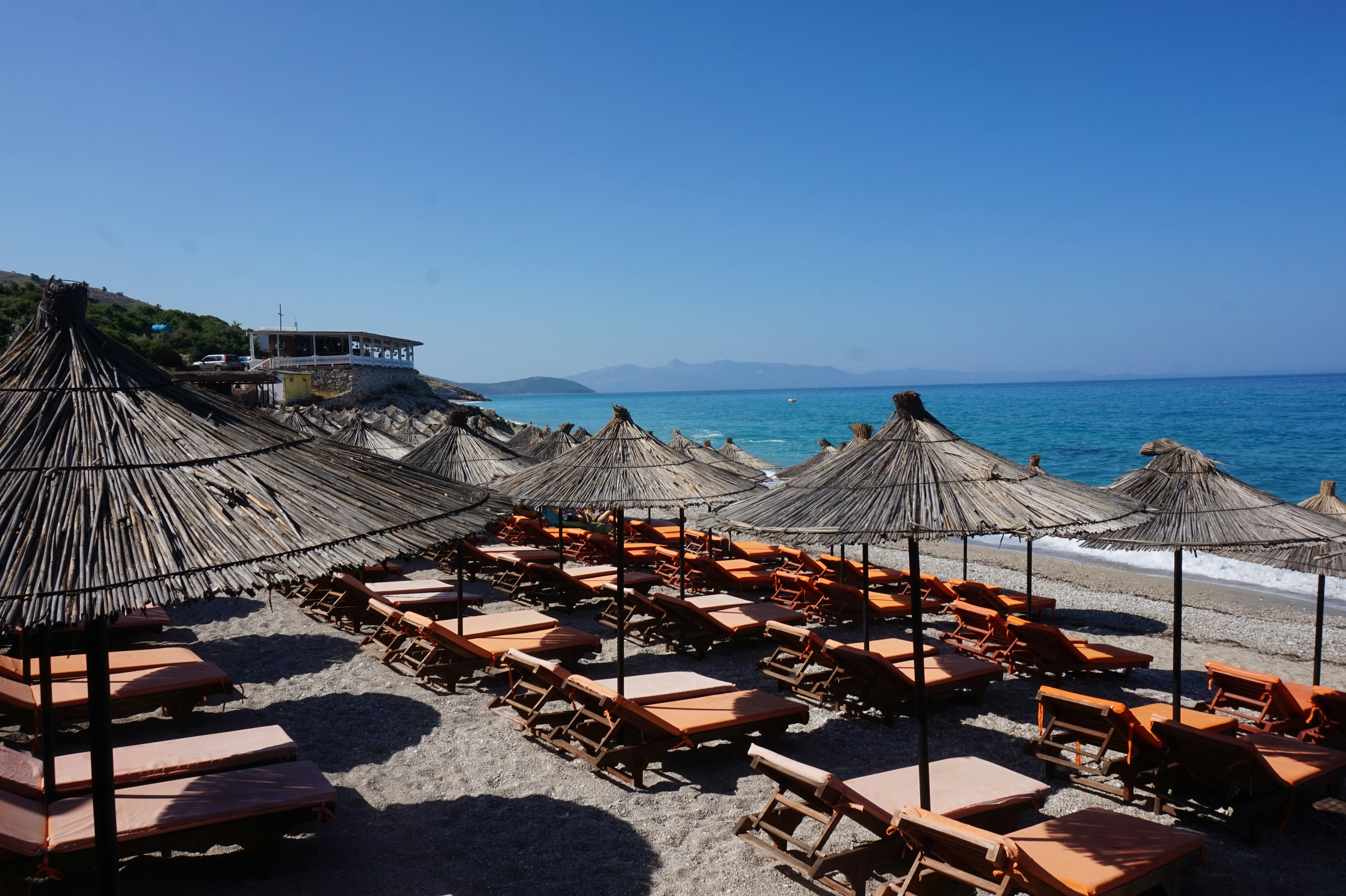 A bunch of umbrellas that are on a beach, Umbrellas and chairs at Lukova beach on the Albanian riviera at the mediterranean. When using my images please cite me as follows: Marie Volkert / Reiseblog Worldonabudget and link to my website: www.worldonabudget.de