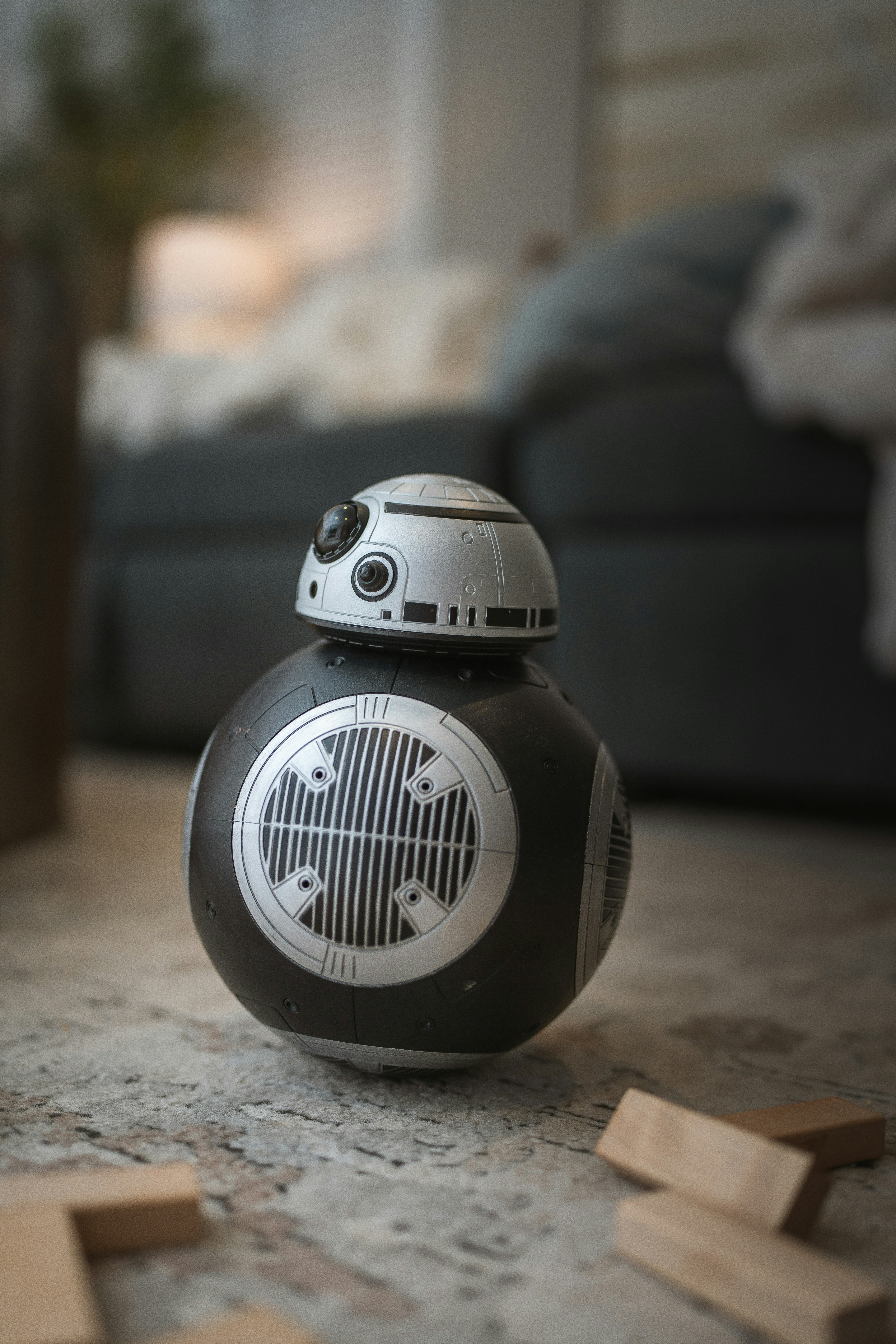A star wars droid toy sitting on the floor