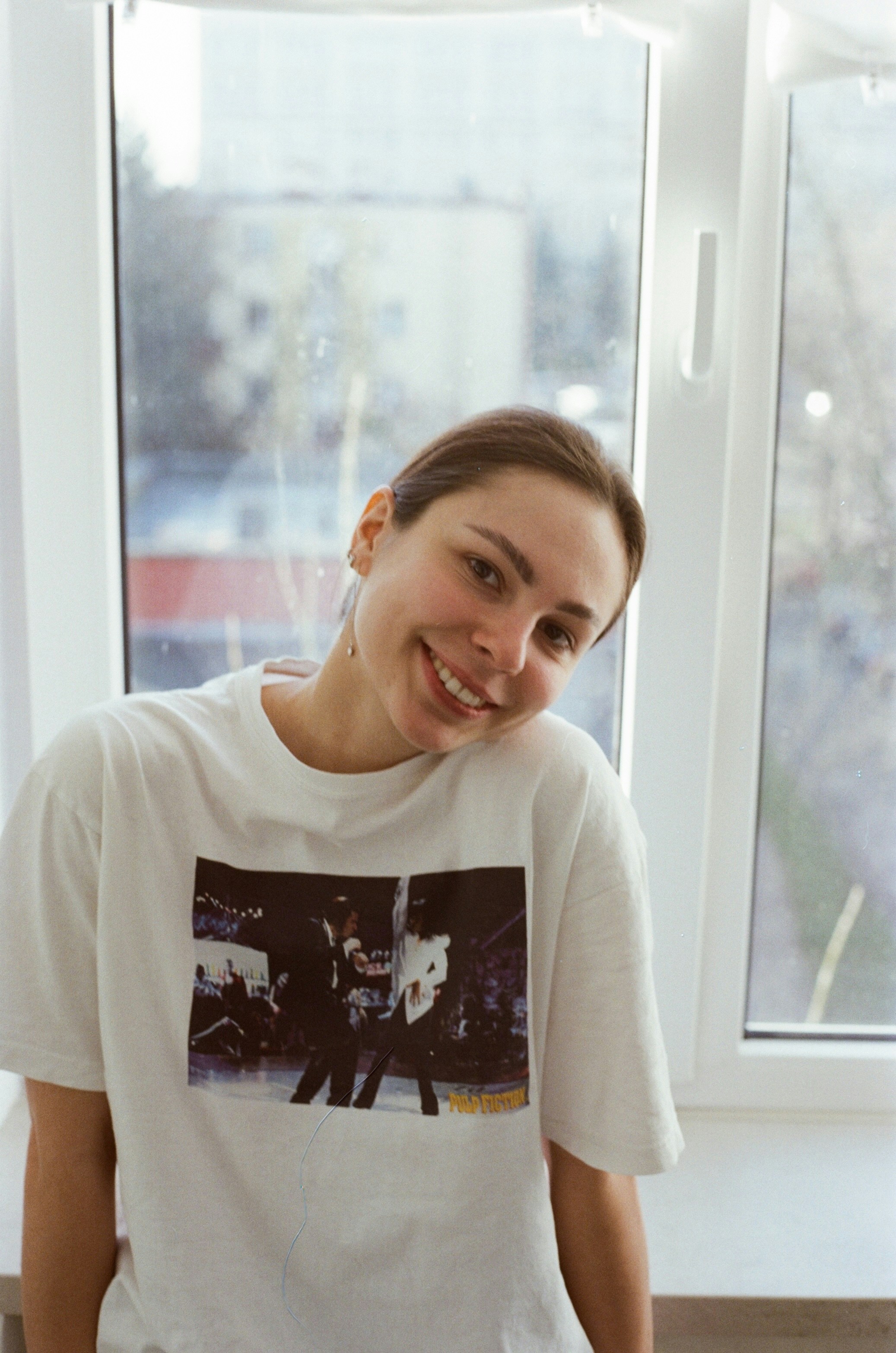 A woman standing in front of a window smiling