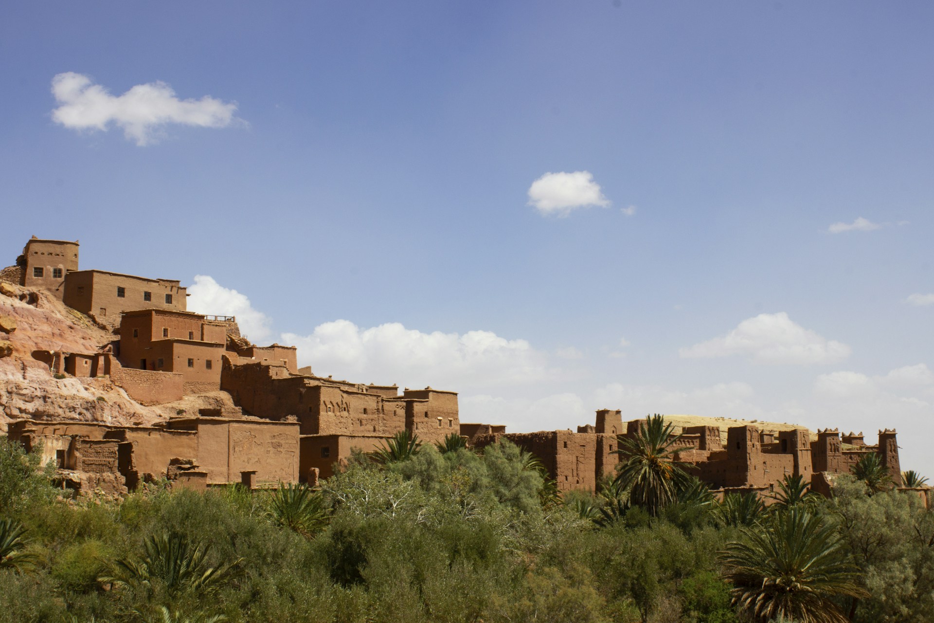 A large brown building sitting on top of a lush green field
