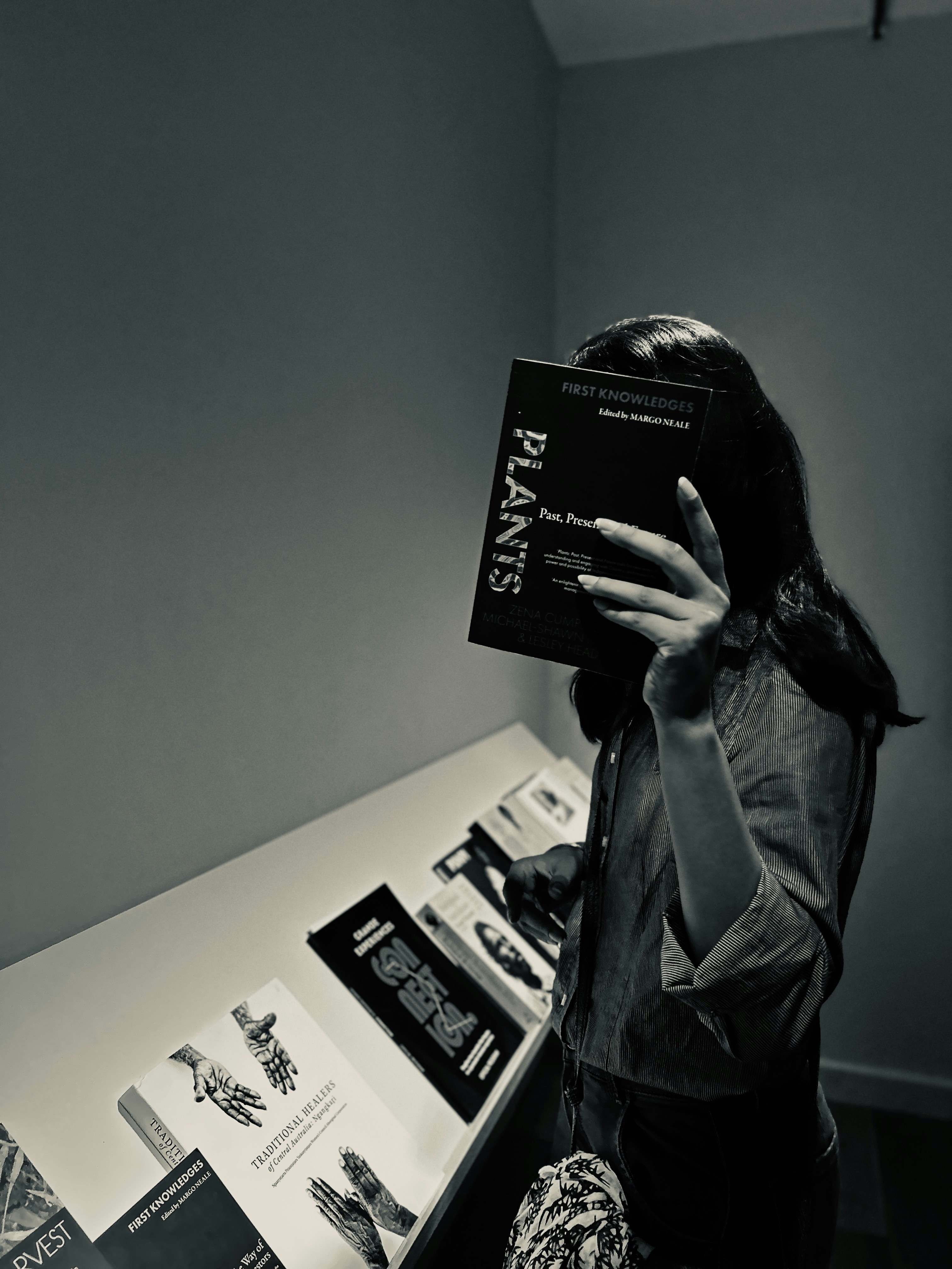 Una mujer de pie frente a un mostrador sosteniendo un libro