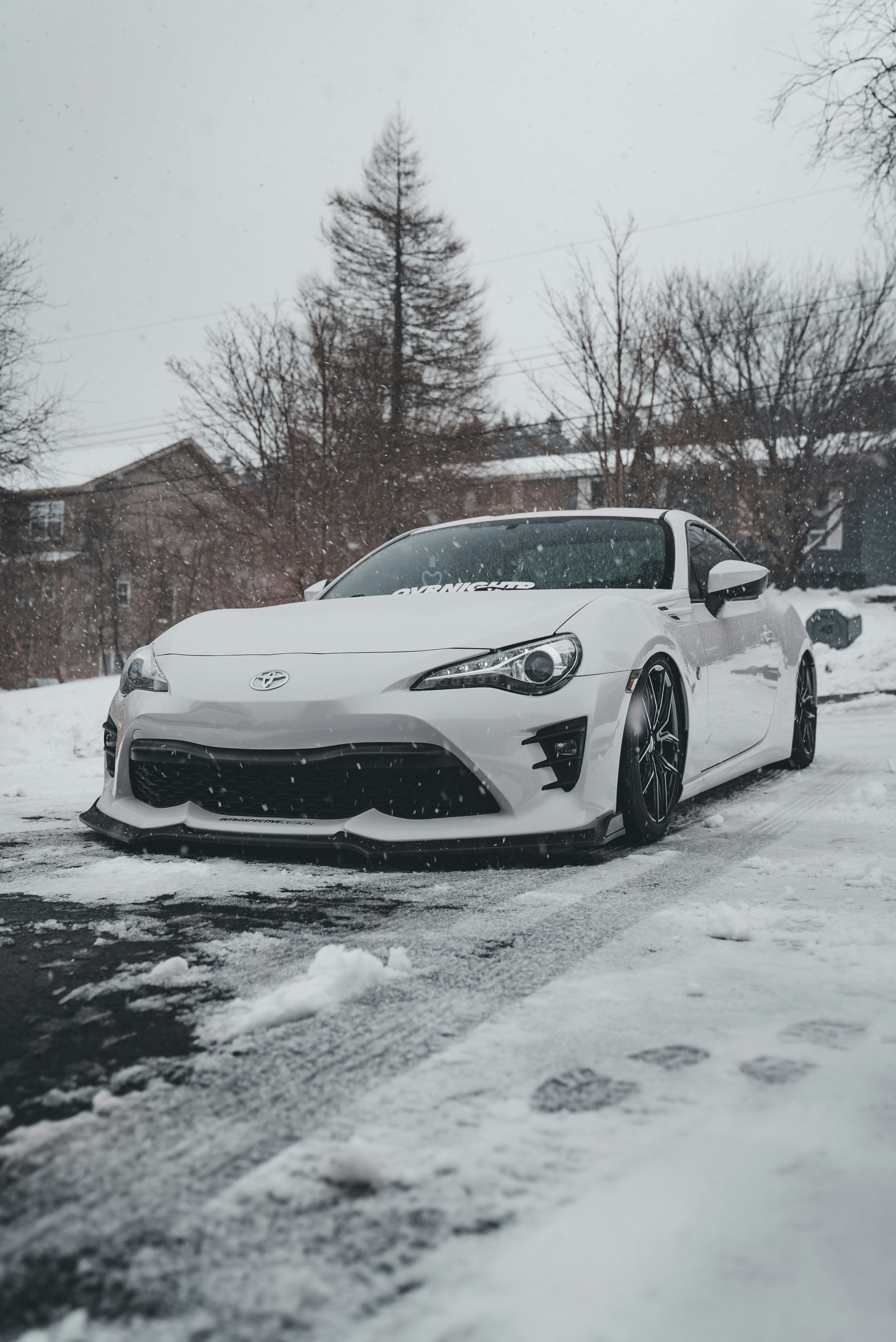 A white car parked on a snowy street