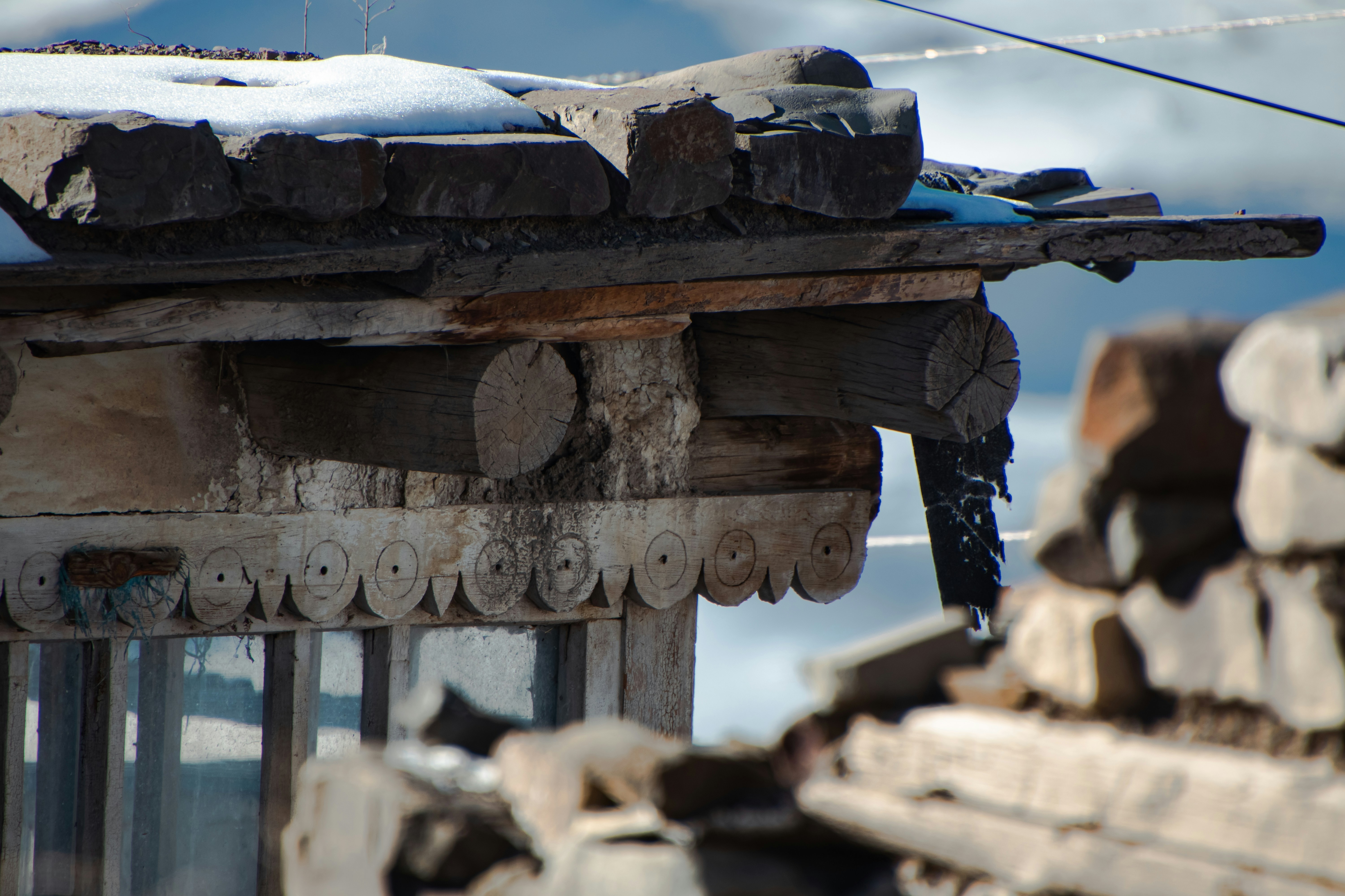 A pile of logs sitting next to a building