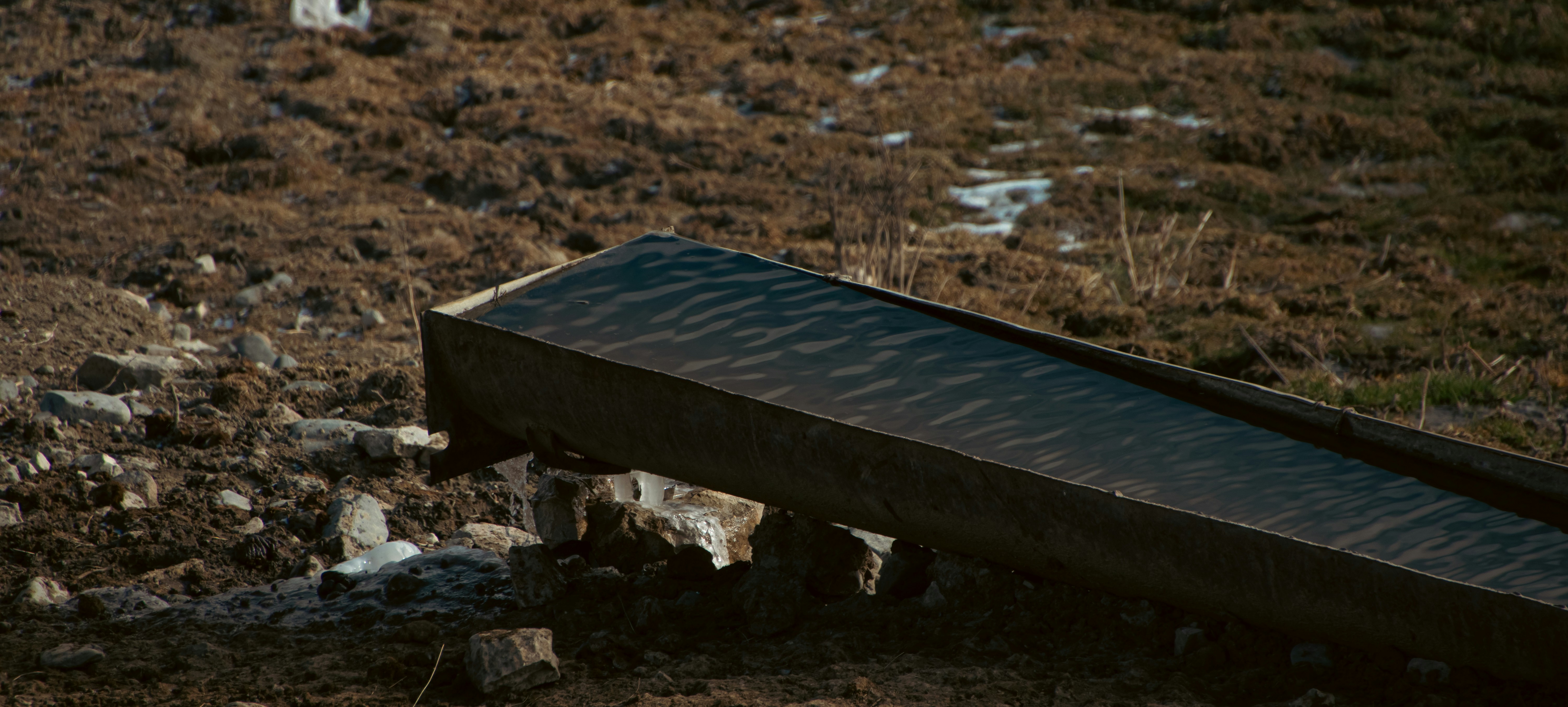 A black bench sitting on top of a grass covered field