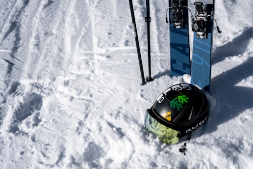 A pair of skis and a snowboard sitting in the snow