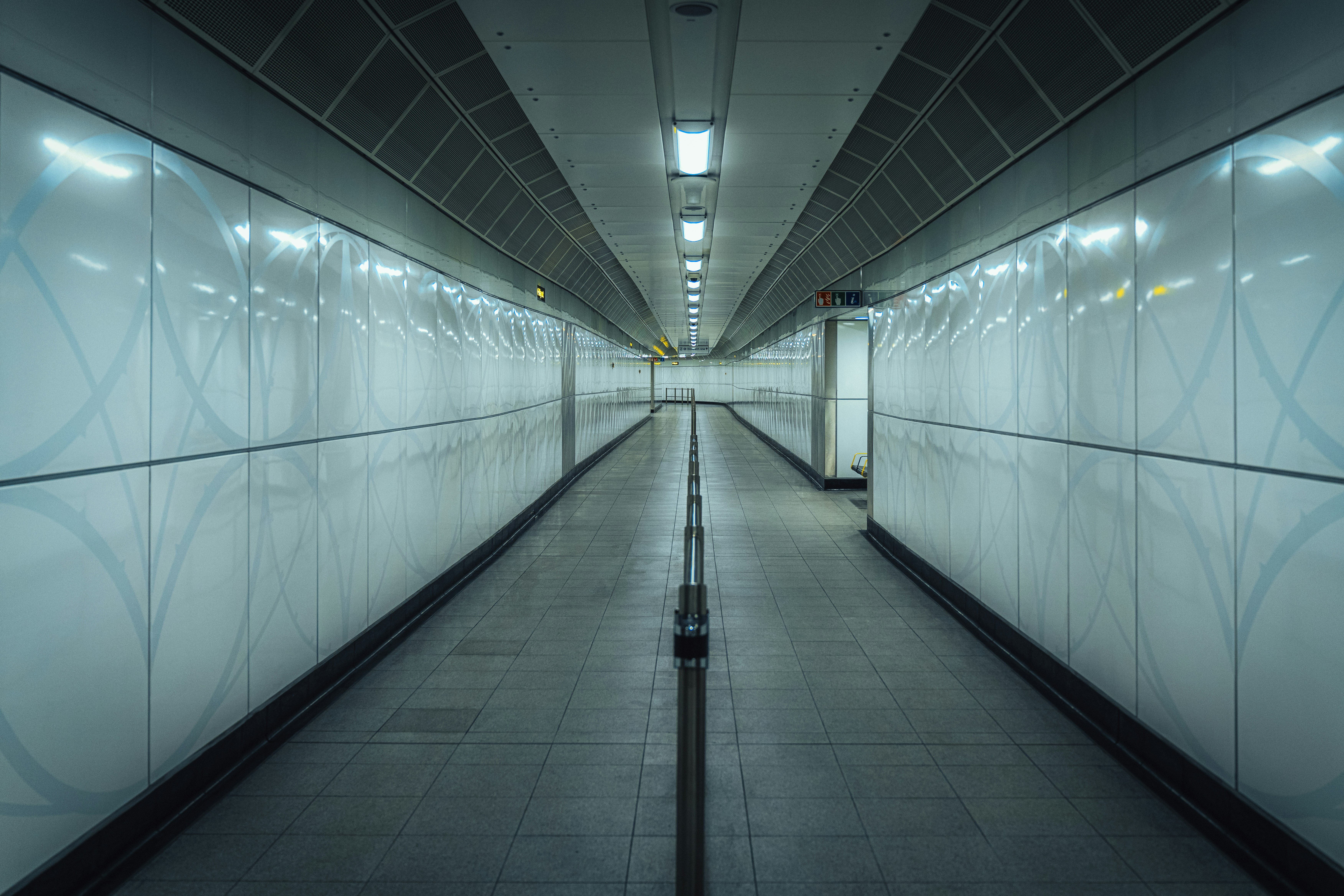 A long hallway with white walls and lights