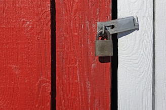 A close up of a lock on a red and white door