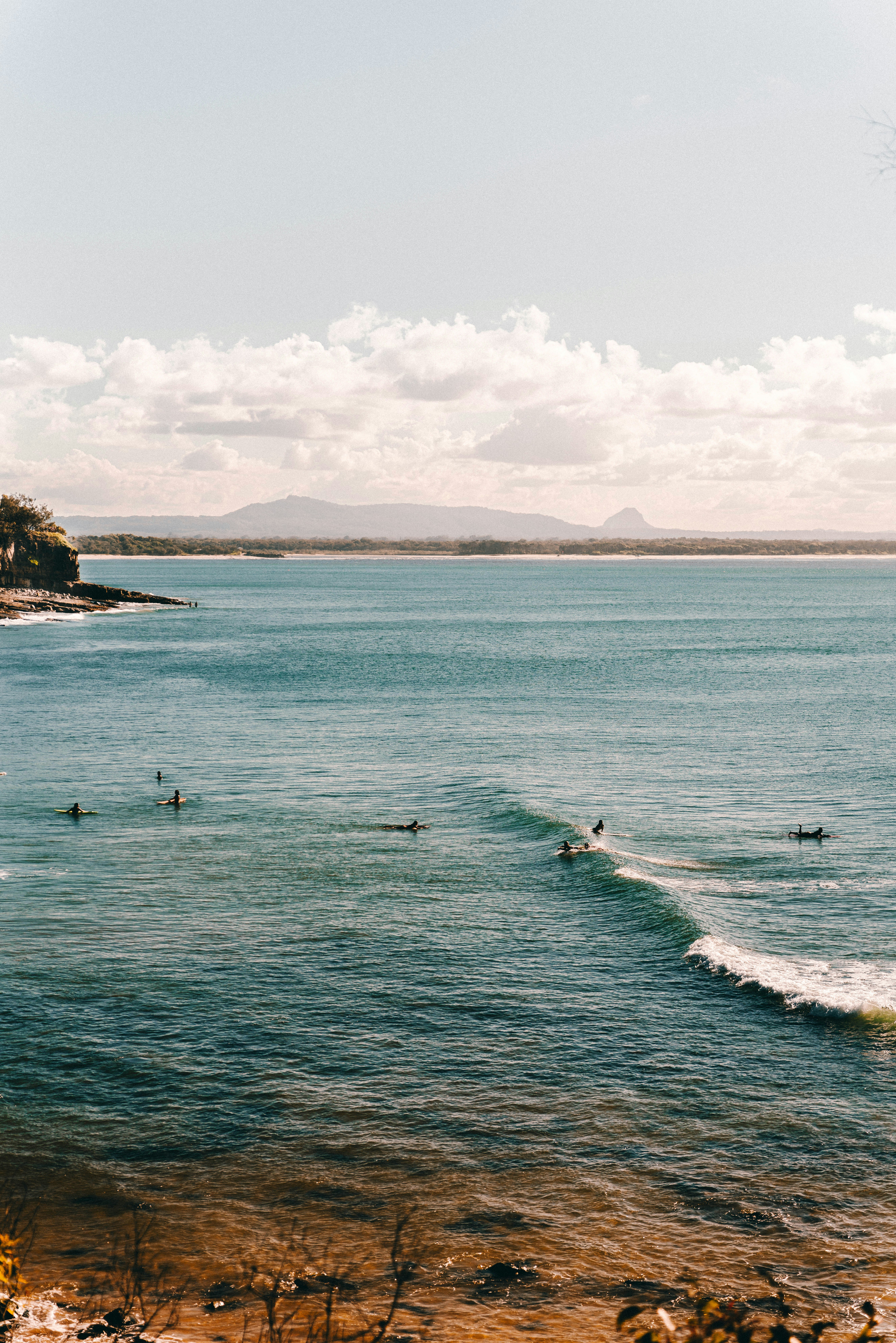 A group of people riding surfboards on top of a body of water