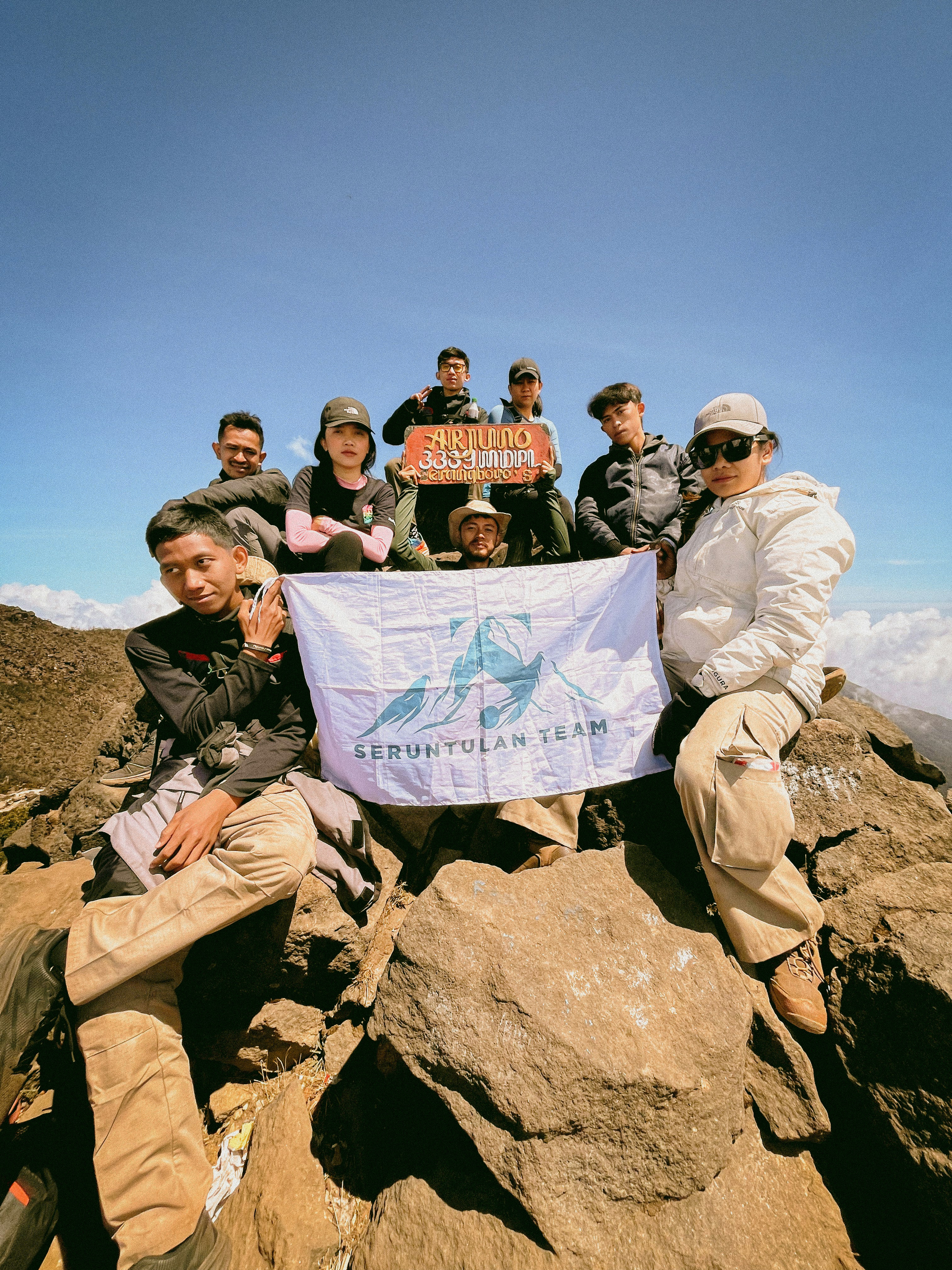 A group of people sitting on top of a mountain
