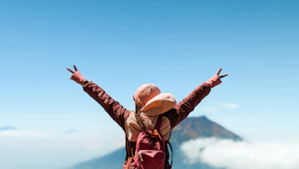 A person standing on top of a mountain with their arms outstretched